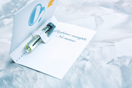 Perfume sample in paper cover on light backgroundの写真素材