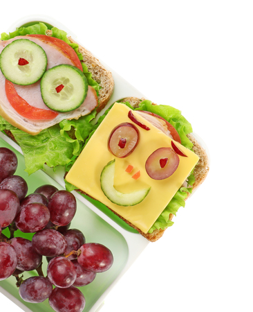 Lunch box with funny sandwiches and grape on white backgroundの写真素材