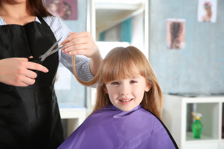 Cute little girl in hairdressing salonの写真素材