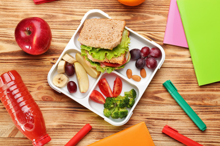 Lunch box with delicious food and stationery on wooden backgroundの写真素材