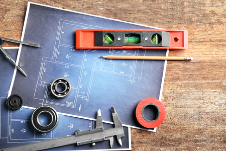 Different kinds of engineering tools and construction drawings on wooden backgroundの写真素材