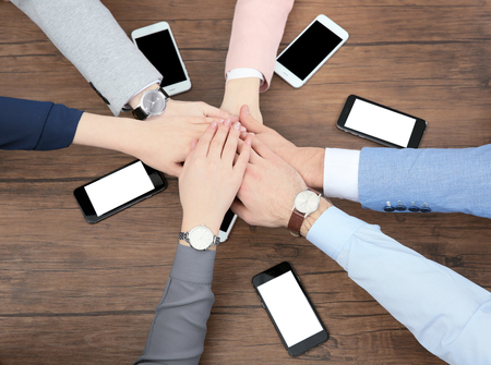 Team work concept. People sitting at table and holding hands together