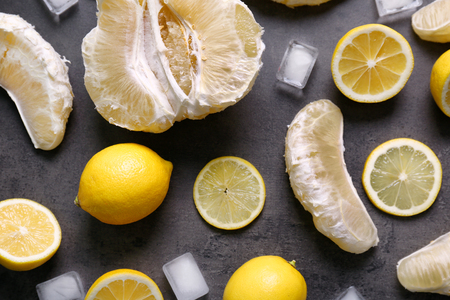 Juicy composition of citrus fruits and ice cubes on grunge backgroundの写真素材