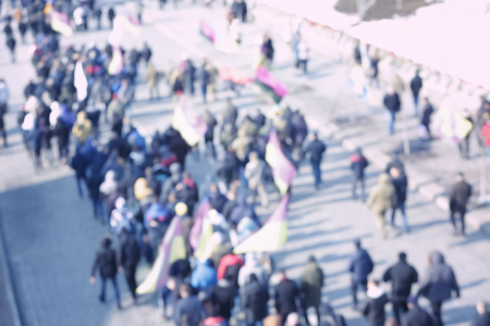 Crowd of people walking on busy city street, blurred view