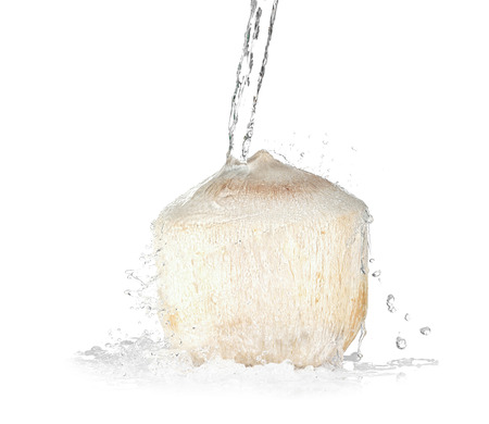 Young peeled coconut with jet of water on white backgroundの写真素材
