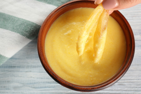 Delicious french fries with cheese sauce, closeup