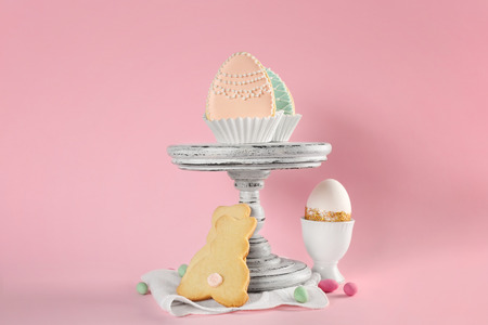Creative composition with Easter cookies on pink background