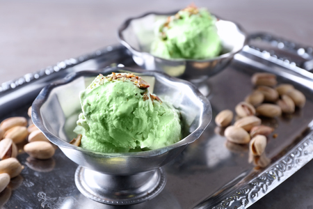 Dessert bowls with delicious pistachio ice cream on metal trayの写真素材