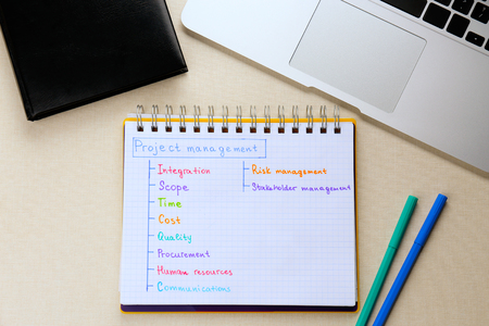 Notebook with written features of PROJECT MANAGEMENT on light backgroundの写真素材