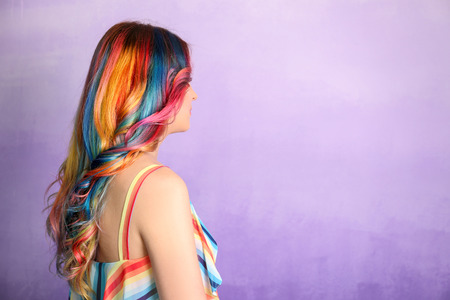 Trendy hairstyle concept. Young woman with colorful dyed hair on color backgroundの写真素材