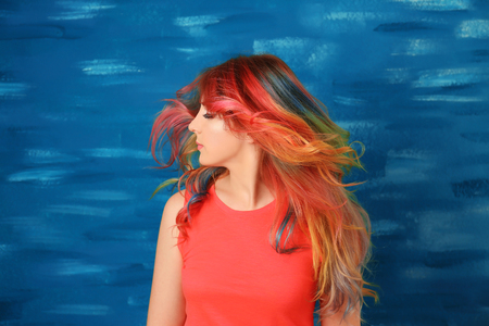 Trendy hairstyle concept. Young woman with colorful dyed hair on color backgroundの写真素材