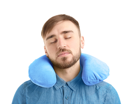 Young man with travel pillow on white backgroundの写真素材