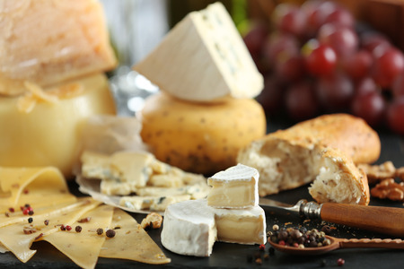 Slate plate with variety of cheese on tableの写真素材