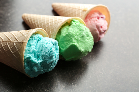 Waffle cones with colorful ice cream on tableの写真素材