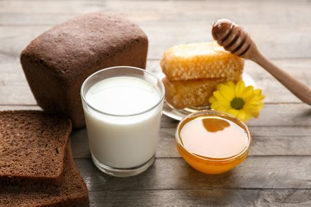Beautiful composition of golden honey and milk on wooden tableの写真素材