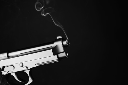 Smoking gun on black backgroundの写真素材