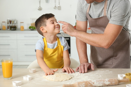 Father and son cooking together in kitchenの写真素材