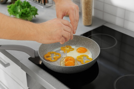 Man frying eggs, closeupの写真素材