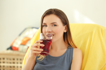 Beautiful woman drinking fresh juice at home