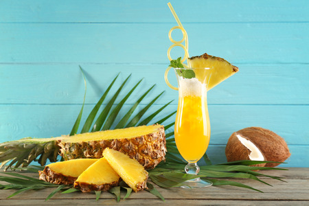 Glass of pineapple juice on wooden table