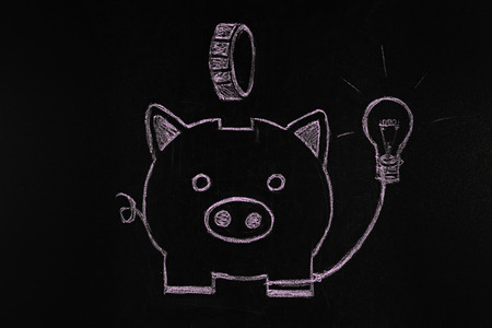 Piggy bank drawn with chalk on black background. Electricity price increasing conceptの写真素材