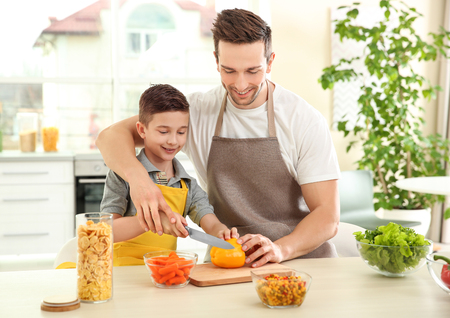 Dad and son cooking at homeの写真素材