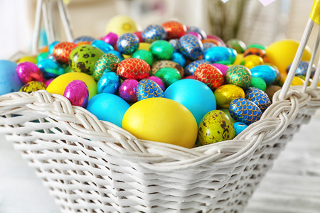 Easter basket with colorful eggs on table, closeup