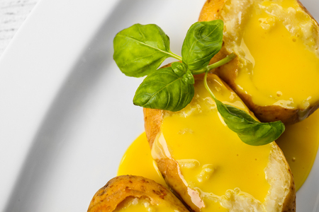 Baked potato with cheese sauce, closeupの写真素材