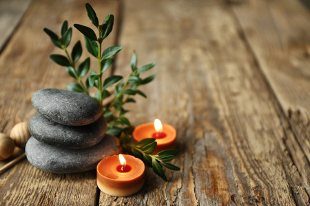Beautiful spa composition with stones and candles on wooden backgroundの写真素材