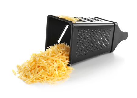 Metal grater and pile of cheese isolated on whiteの写真素材