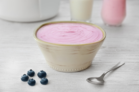 Bowl with yogurt on wooden tableの写真素材