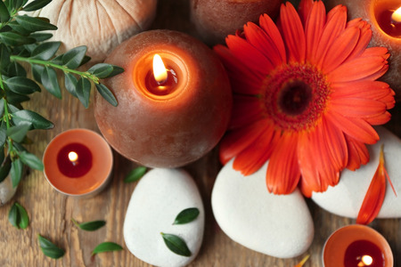 Spa composition with stones, candles and beautiful flower on wooden backgroundの写真素材