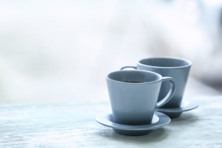 Cups with hot tea on wooden table against blurred backgroundの写真素材