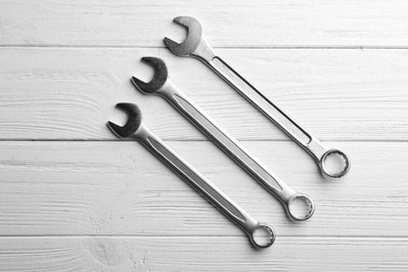 Combination wrenches on white wooden table