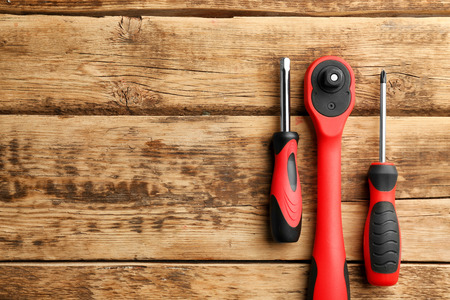 Ratchet and screwdrivers on wooden backgroundの写真素材