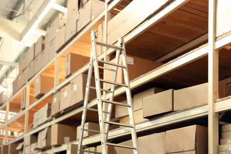 Ladder and boxes with goods in wholesale warehouseの写真素材