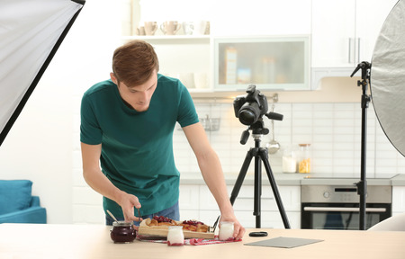 Young man photographing food in photo studioの写真素材