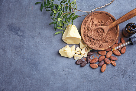 Beautiful composition with cocoa butter lotion and ingredients on tableの写真素材