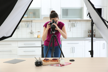 Young woman photographing food in photo studioの写真素材