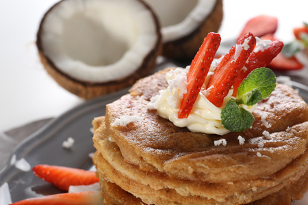 Stack of delicious coconut pancakes with strawberry and butter cream, close upの写真素材