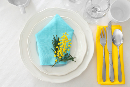 Table setting with floral decor on white tableclothの写真素材