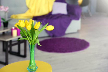 Vase with beautiful yellow tulips on blurred backgroundの写真素材