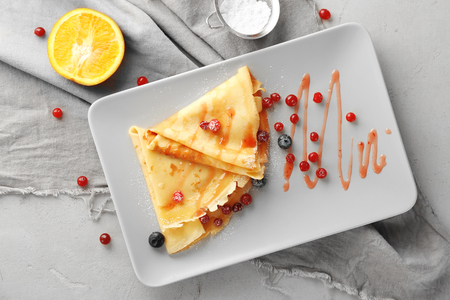 Tasty pancakes with berry sauce for breakfast on plateの写真素材