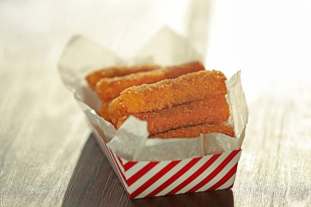 Paper box with cheese sticks on tableの写真素材