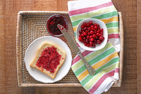 Tasty toast with berry jam for breakfast on wicker trayの写真素材