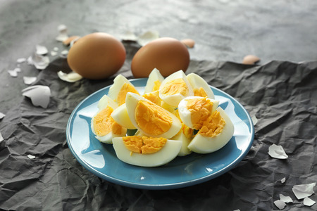 Plate with hard boiled sliced eggs on table. Nutrition conceptの写真素材