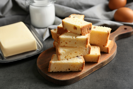 Wooden board with delicious sliced butter cake on tableの写真素材