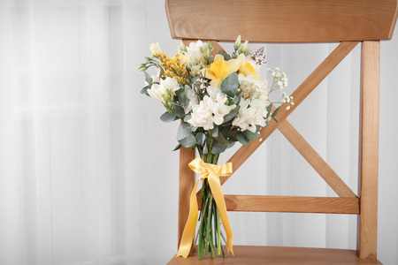 Beautiful bouquet with freesia flowers on chairの写真素材