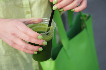 Woman holding cup of green smoothie, closeupの写真素材