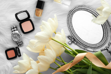 Beautiful composition of cosmetics with tulips on furry backgroundの写真素材